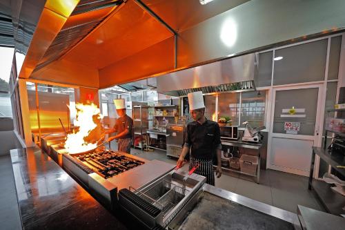 two chefs in a kitchen preparing food in a kitchen at Lavendish Hills Kandy in Kandy
