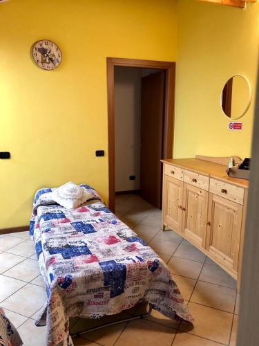 a room with a bed and a counter with a clock on the wall at Monolocale vicino Milano CIR 00014 in Lodi