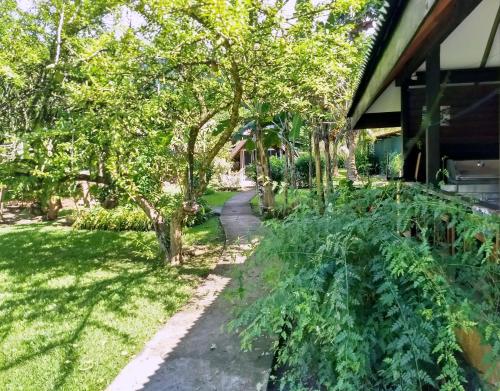 a garden with trees and a walkway at Pension Les Trois Cascades in Uturoa