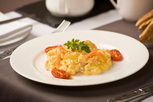 a white plate of food with sausage and eggs at Distant Hills Guest House in Spean Bridge