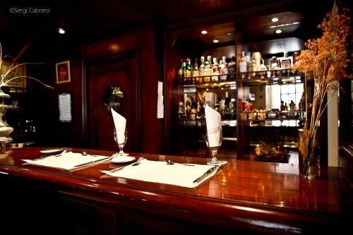 a bar with a table with napkins and glasses on it at Hotel Pintor Marsà in Tárrega