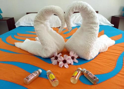 a bed with two swans and four bottles of coke at Pension Les Trois Cascades in Uturoa