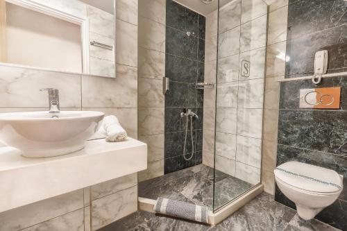 y baño con ducha, lavabo y aseo. en Sofia Hotel en Heraclión