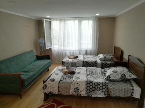 1 Schlafzimmer mit 2 Betten und einem Sofa in der Unterkunft Tbilisi guesthouse Nini in Tbilisi City