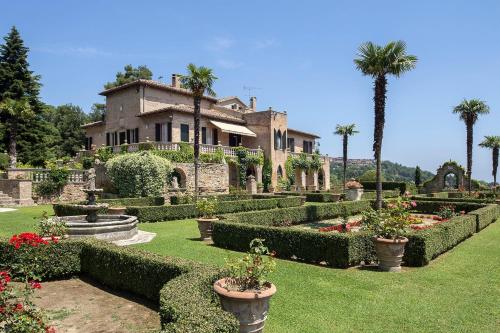 a house with a garden with plants and palm trees at Villa Cattani Stuart XVII secolo in Pesaro