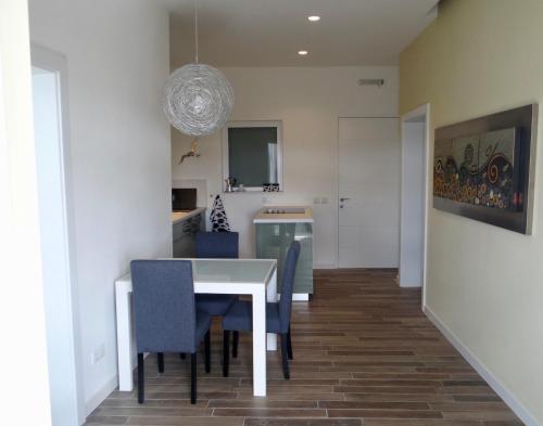 a dining room with a white table and blue chairs at Three Cities Apartments in Cospicua