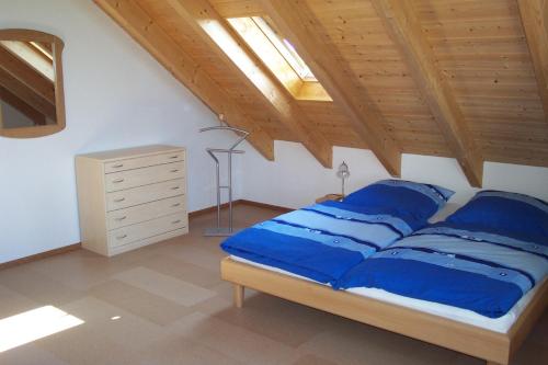 ランツベルク・アム・レヒにあるFerienwohnung Rosmarie Schulmeisterのベッドルーム1室(青い枕と木製の天井付)