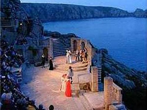 a group of people standing on a stage by the water at Dunedin Guest House in Penzance