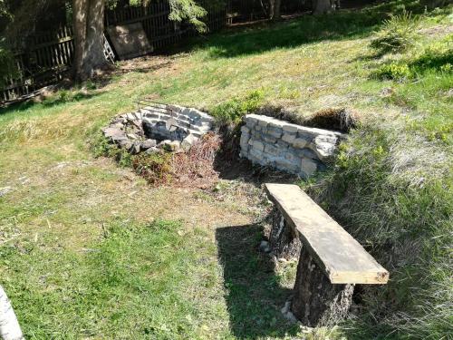 a bench sitting in the grass next to a fire pit at Chata Wostry in Bílá