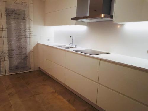 kuchnia z białymi szafkami i zlewem w obiekcie SANXENXO SUITES CON VISTAS Muy Bien Ubicado w mieście Sanxenxo