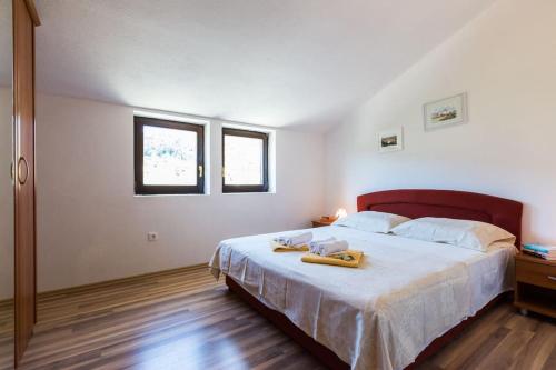 a bedroom with a bed with two towels on it at Slanac 2 in Veli Iž