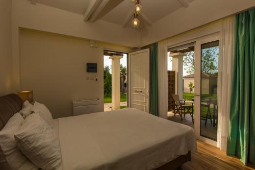 a bedroom with a bed and a sliding glass door at Fragos Garden Studios in Kyllini
