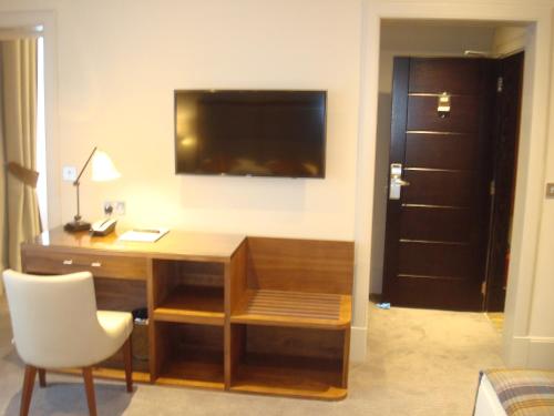 a room with a desk with a television on a wall at Cruachan Hotel in Fort William