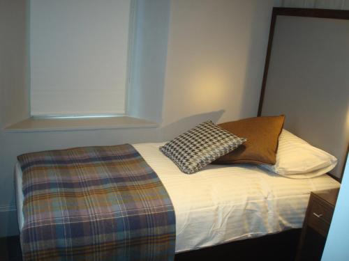 a bed with two pillows on it in a room at Cruachan Hotel in Fort William