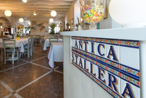 a restaurant with tables and a sign that reads anticaiya at Hotel Antica Stallera in Cannobio