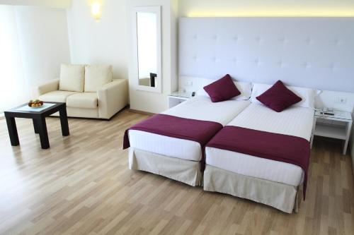 a bedroom with a large bed and a chair at Hotel Albahia Alicante in Alicante