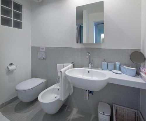 La salle de bains est pourvue d'un lavabo blanc et de toilettes. dans l'établissement Modern sunny apartment in residental area, à Venise