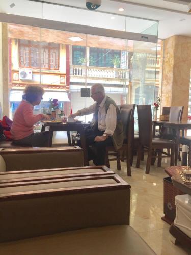 twee mensen aan een tafel in een restaurant bij Son Ha Sapa Hotel Plus in Sa Pa