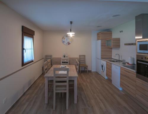 a kitchen and dining room with a table and chairs at Casa Cantera del Berrocal in Ortigosa del Monte