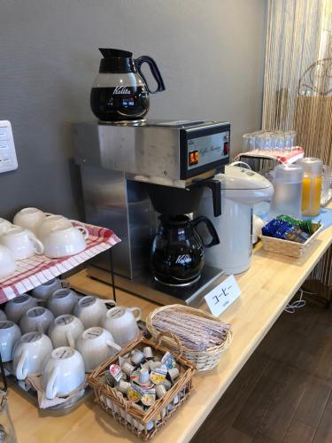 a counter with a coffee maker and tea pots on it at Gran Hotel in Shingu