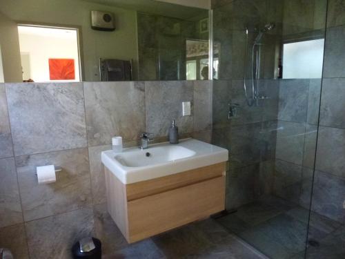 a bathroom with a sink and a shower at Idyllic Country Garden in Manakau