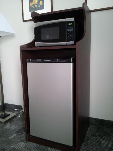a microwave sitting on top of a refrigerator at Midland Inn & Suites in Midland