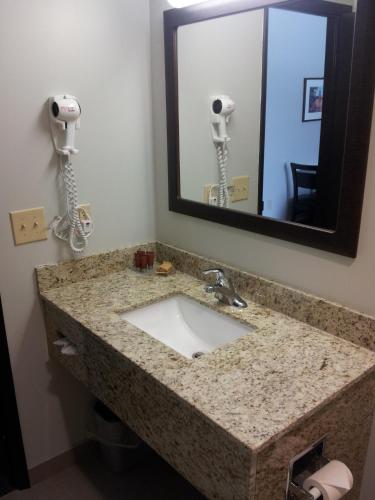 a bathroom with a sink and a mirror at Midland Inn & Suites in Midland