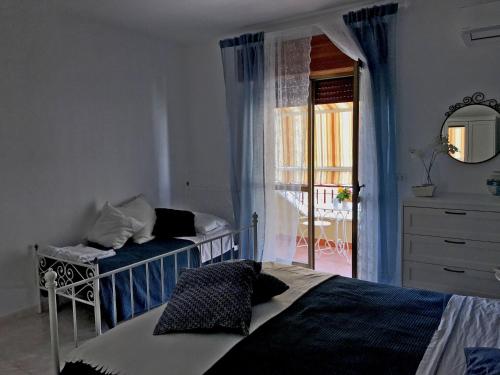 a bedroom with a bed and a mirror and a window at La casa del Professore in Tortora