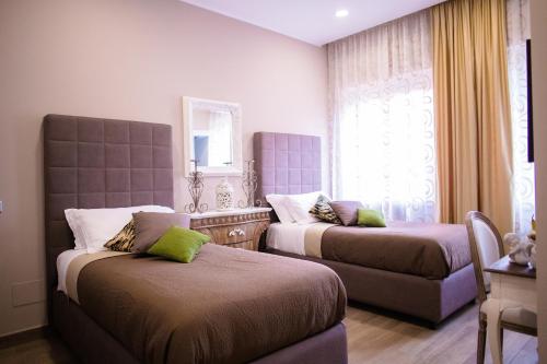 a bedroom with two beds and a window at Relais Villa Italia in Selcetta