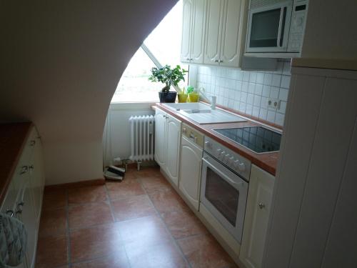 a kitchen with white cabinets and a sink and a window at Maisonette am Belchen in Bad Krozingen