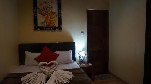 a bedroom with a bed with a heart decoration on it at Bima Sakti Homestay Echo Beach Canggu in Canggu