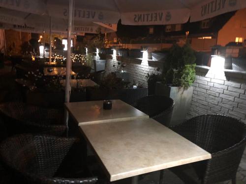 a table and chairs in a restaurant with lights at Hotel & Restaurant Blume in Wolfsburg