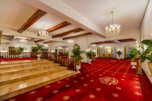 a ballroom with a red carpet and a dance floor at Aurelius Imparatul Romanilor Hotel & SPA in Poiana Brasov