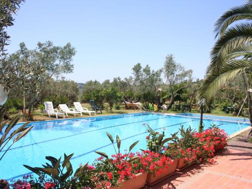 una piscina in un resort con fiori e palme di Cozy Holiday Home in Calabria with Garden a Maida