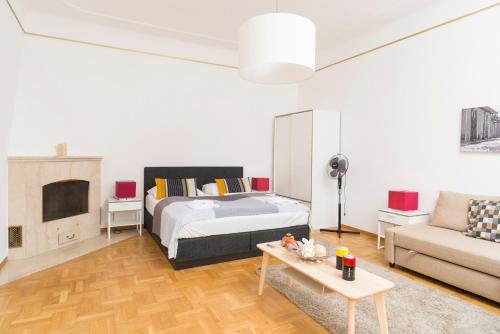 ウィーンにあるDe Luxe Suite Staatsoperのベッドルーム1室(ベッド1台、ソファ、テーブル付)