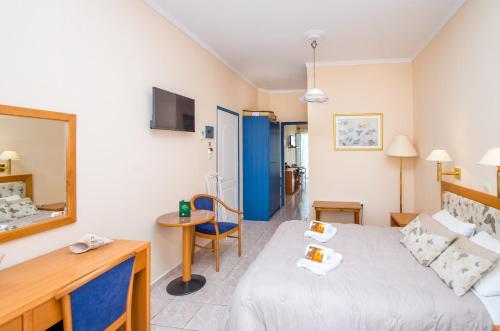 ein Hotelzimmer mit einem Bett und einem Spiegel in der Unterkunft Syros Atlantis in Vári