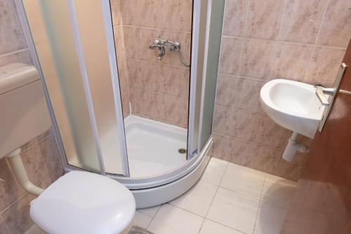 a bathroom with a shower and a toilet and a sink at Holiday Resort Balota in Viganj