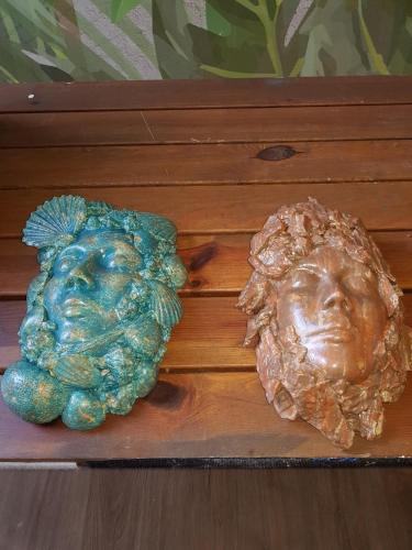 two figurines of a face and a bust on a table at Hotel Lucerna in Castiglione della Pescaia
