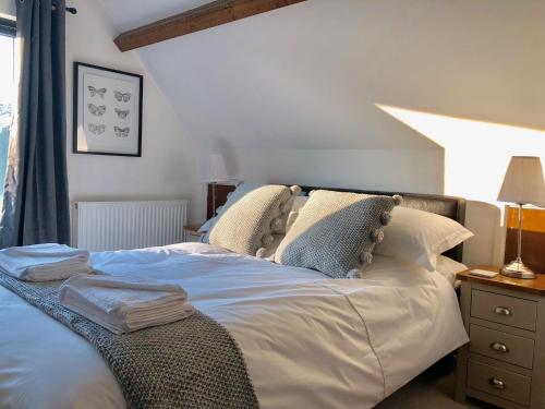 a bedroom with a bed with pillows and a window at The Stable Barn *On the edge of the New Forest* in Downton