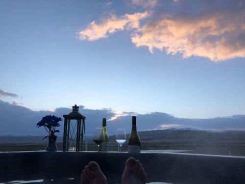 a group of wine bottles and glasses on a bath tub at Akurgerði Guesthouse 8 - Country Life Style in Ölfus