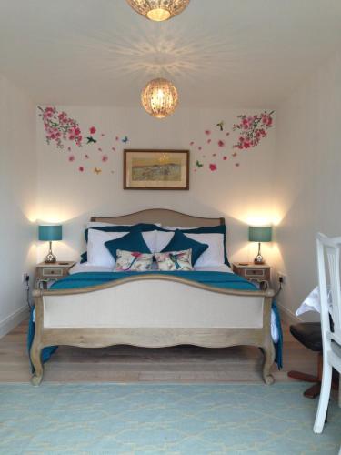ein Schlafzimmer mit einem Bett mit Blumen an der Wand in der Unterkunft Blossom Folly in Dunvegan
