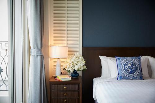 a bedroom with a bed and a table with a lamp at The Rose Residence, Bangkok in Bangkok