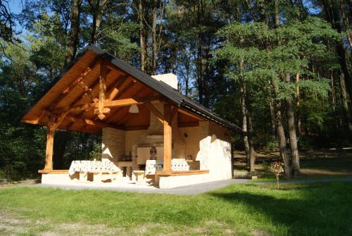 a pavilion with tables and chairs in a park at 3pokoje - Domek lub Pokój pod lasem na odludziu, jacuzzi, sauna, kominek, Roztocze in Susiec