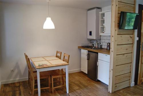 a kitchen with a table and a small table and chairs at 3pokoje - Domek lub Pokój pod lasem na odludziu, jacuzzi, sauna, kominek, Roztocze in Susiec