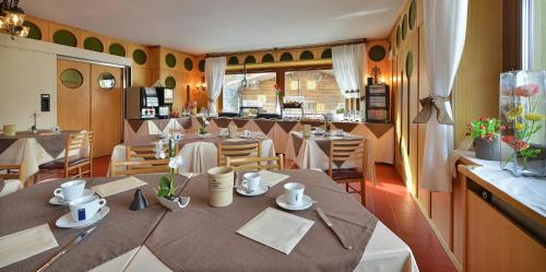 un ristorante con tavoli e sedie in una stanza di Hotel Loredana a Livigno