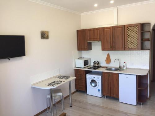 a kitchen with wooden cabinets and a sink and a stove at Polyana Apart in Polyana