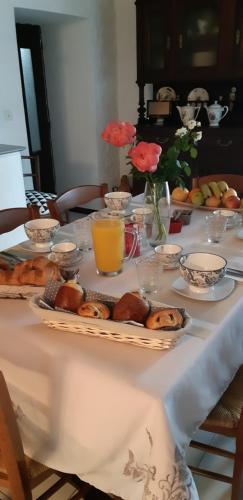 einen Tisch mit einem weißen Tischtuch mit Gebäck darauf in der Unterkunft Casa san salvadore in Favalello
