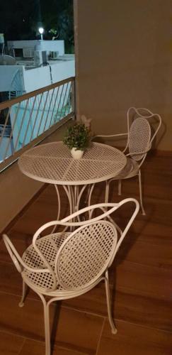 a table with two chairs and a plant on a balcony at City Apartments in Eilat