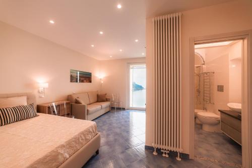 una camera con letto e divano e un bagno di Le Esperidi a Ravello
