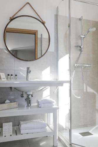 une salle de bain avec une douche, un lavabo et un miroir dans l'établissement Hotel La Bienvenue, à La Croix-Valmer